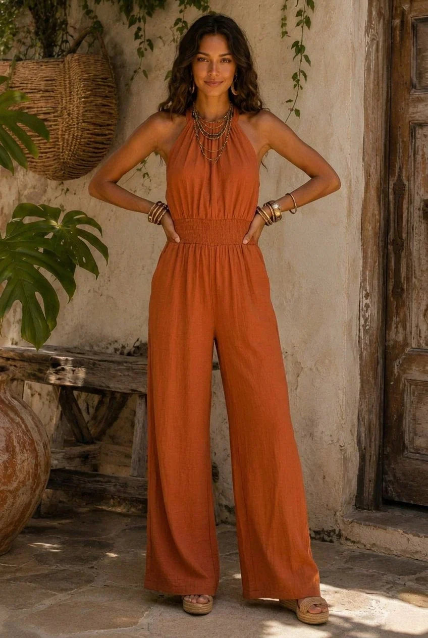Mono de algodón y lino color con cuello halter, cintura fruncida y perneras anchas.