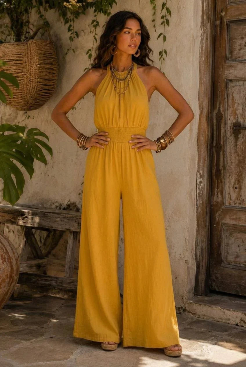 Mono de algodón y lino color con cuello halter, cintura fruncida y perneras anchas.